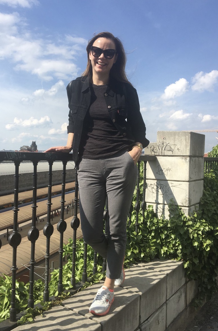 Before styling: casual balcony outfit with black jacket, grey pants, and sneakers