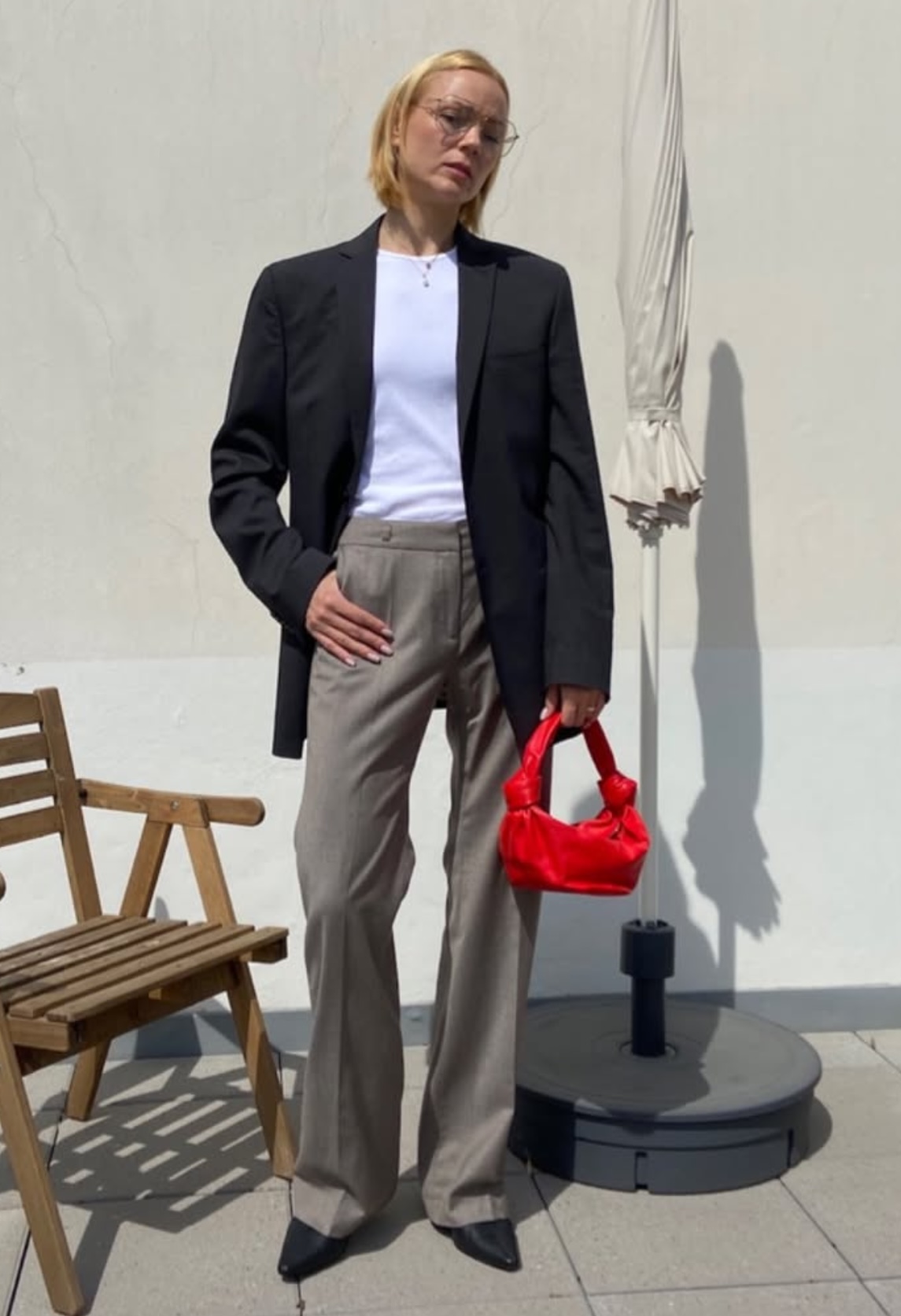 Client outfit with black blazer, grey trousers, and red bag