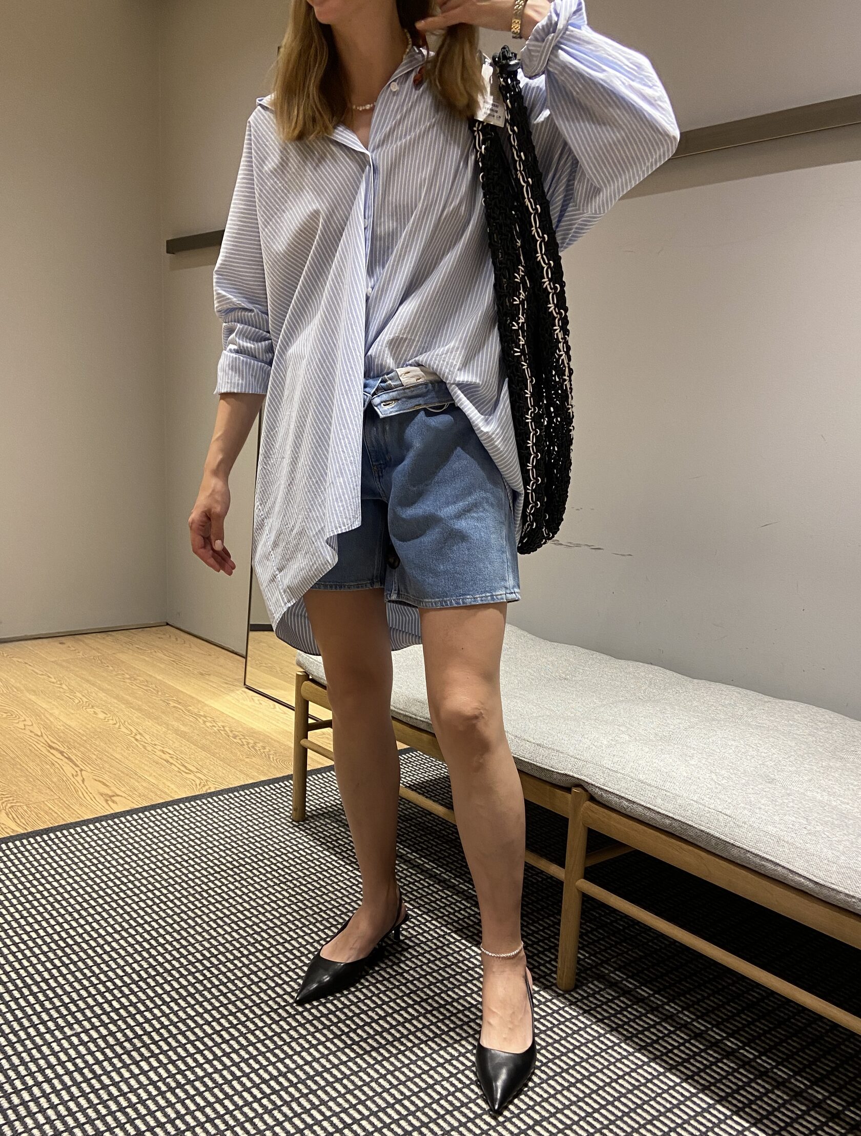 Client outfit with oversized blue shirt, denim shorts, and pointed flats