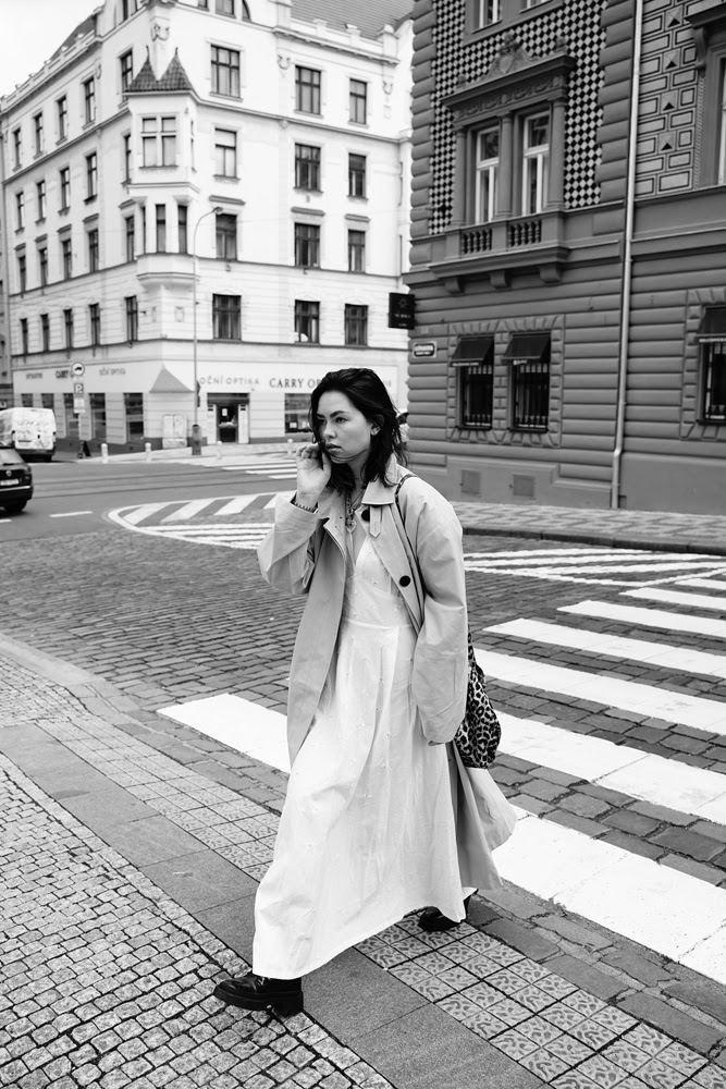 Ann Strunevskaia walking through a city street in a black and white editorial photograph